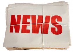 The word "news" in red letters on white background on top of a pile of newspapers