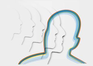 Demonstrating empathy in the workplace. multi-coloured outline of a head with various other white outlined heads filtering into it.