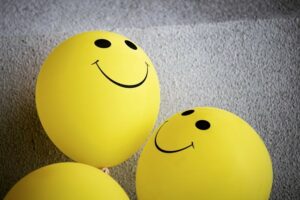 Two yellow smiley emoji against a grey textile backdrop