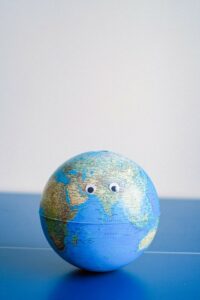 A sphere shaped miniature of the earth with a pair of googly eyes