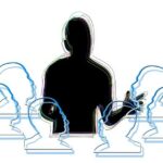 A silhouette of a person standing talking to a group of 6 represented by head outlines in a circle around the speaker
