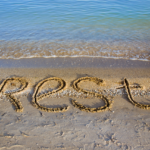 a beach tideline with the word rest written on the sand
